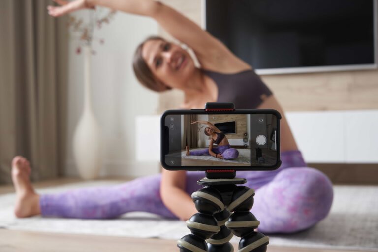 Woman filming herself at home, illustrating the process of creating engaging short-form video content for social media platforms.